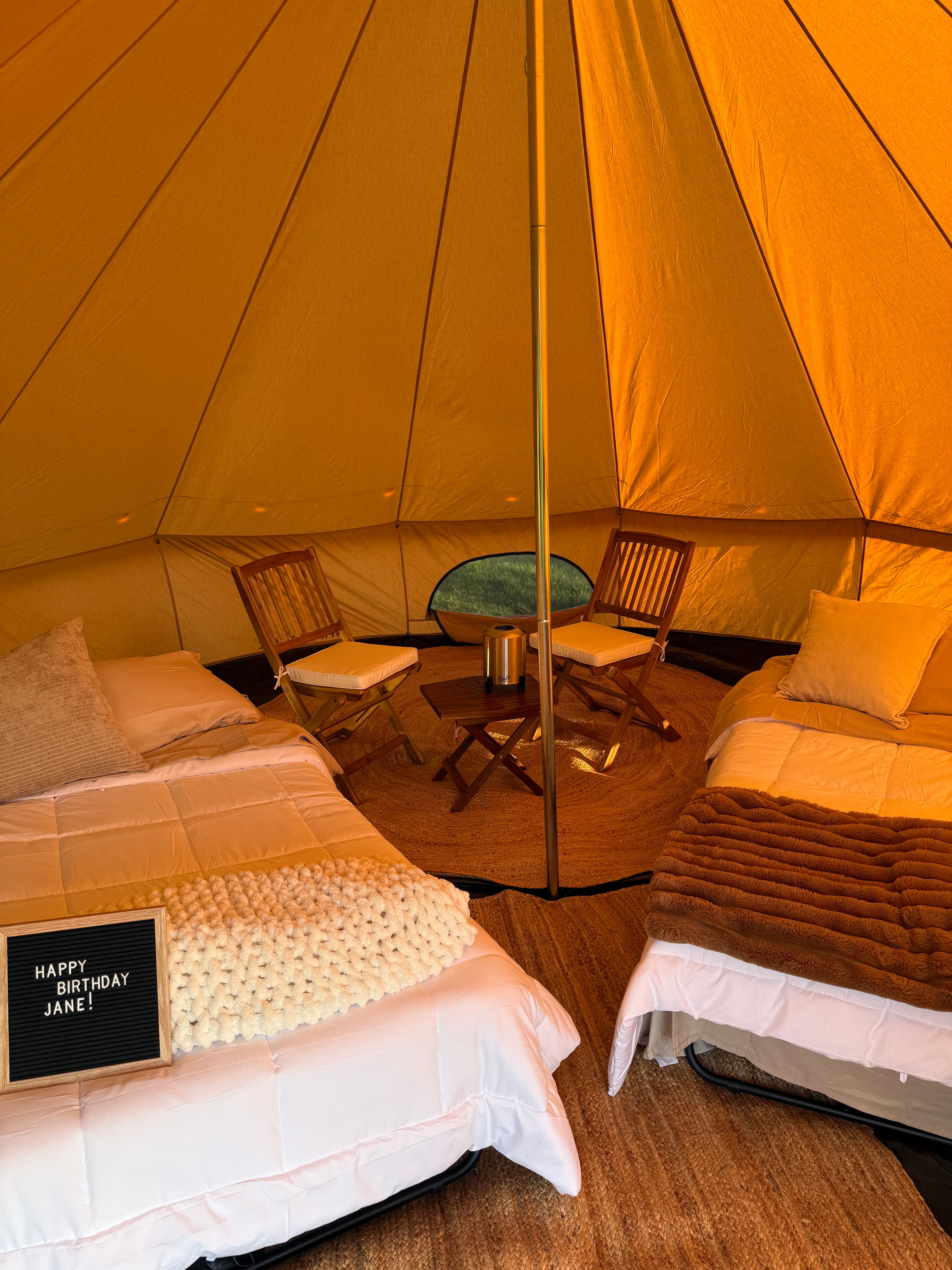 Birthday tent interior with letter board and cozy bedding